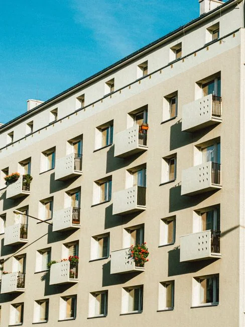 Un membre du personnel en équipement de protection désinfecte un bureau à l’aide d’un appareil de fumigation en pleine journée.